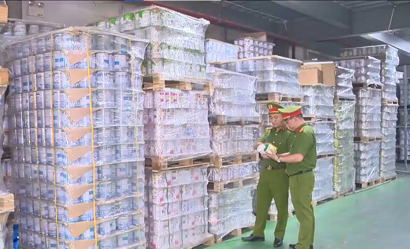 Lực lượng chức năng kiểm tra kho hàng trong đường dây sản xuất 573 loại sữa bột giả. Ảnh: VTV