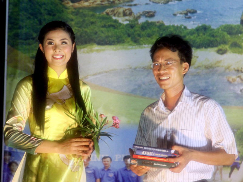 Hoa hậu Ngọc Hân trao sách cho đại diện bà con Cô Tô trong buổi giao lưu văn nghệ