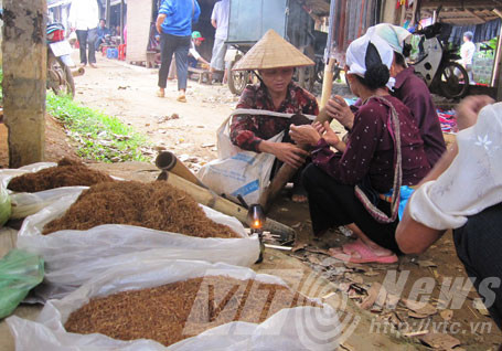 Một số phụ nữ đứng tuổi ở Lạc Sơn vẫn thường hút thuốc lào giữa chợ.