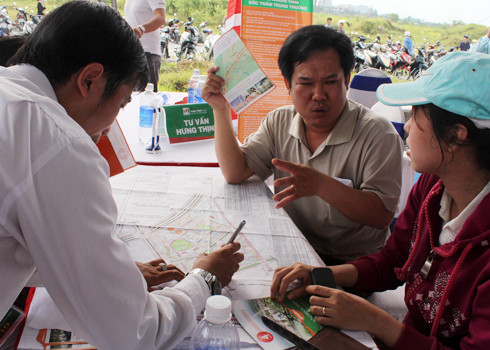 Một nhóm khách hàng đang bàn luận và chọn vị trí đất nền trên bản đồ tại dự án cách TP HCM 50 km. Ảnh: Vũ Lê