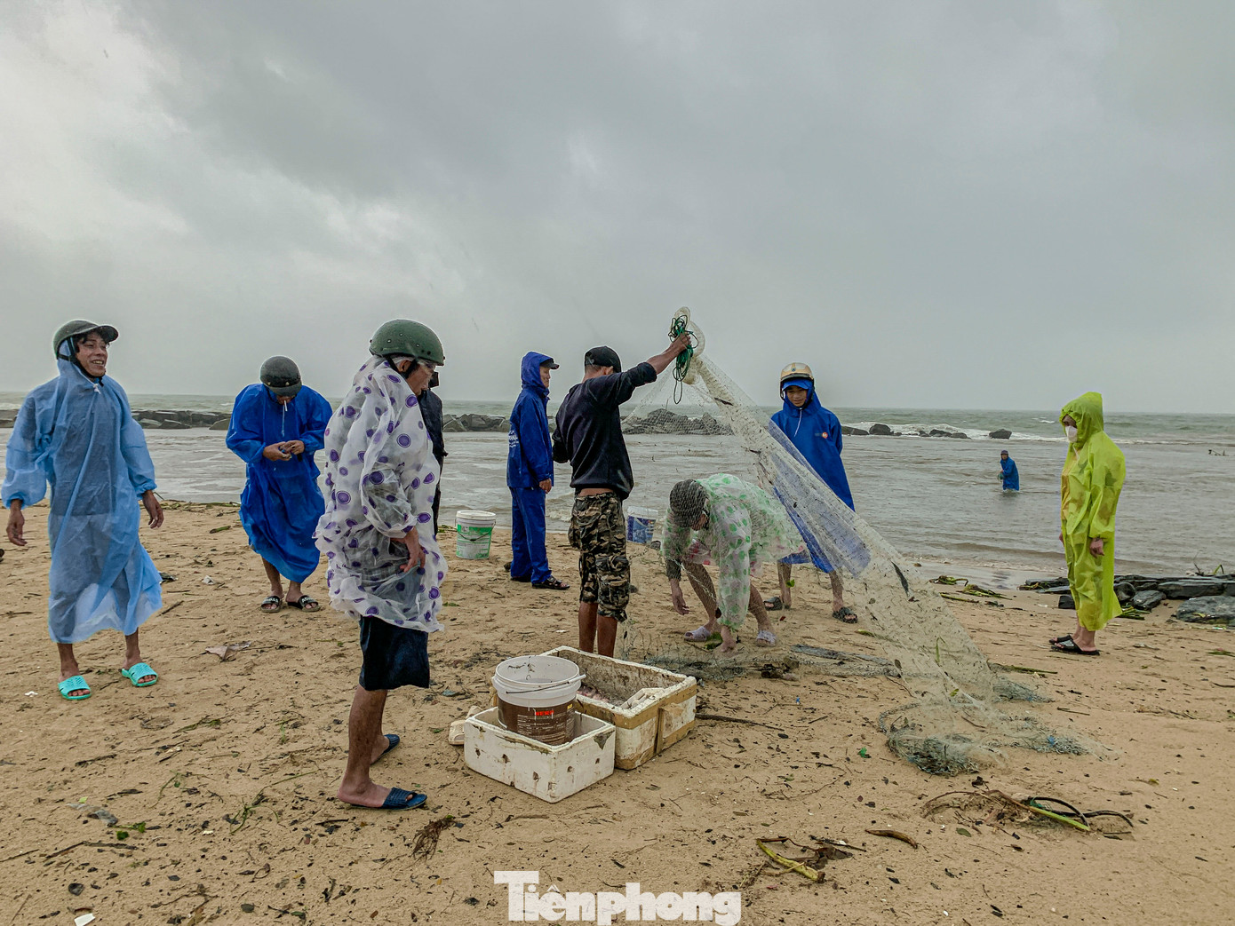 Sáng ngày 5/11, bất chấp thời tiết xấu, nhiều người dân Đà Nẵng ra khu vực kênh Phú Lộc trên đường Nguyễn Tất Thành (quận Thanh Khê), lội xuống biển giăng lưới, đón dòng nước từ cống đổ ra biển để bắt cá.