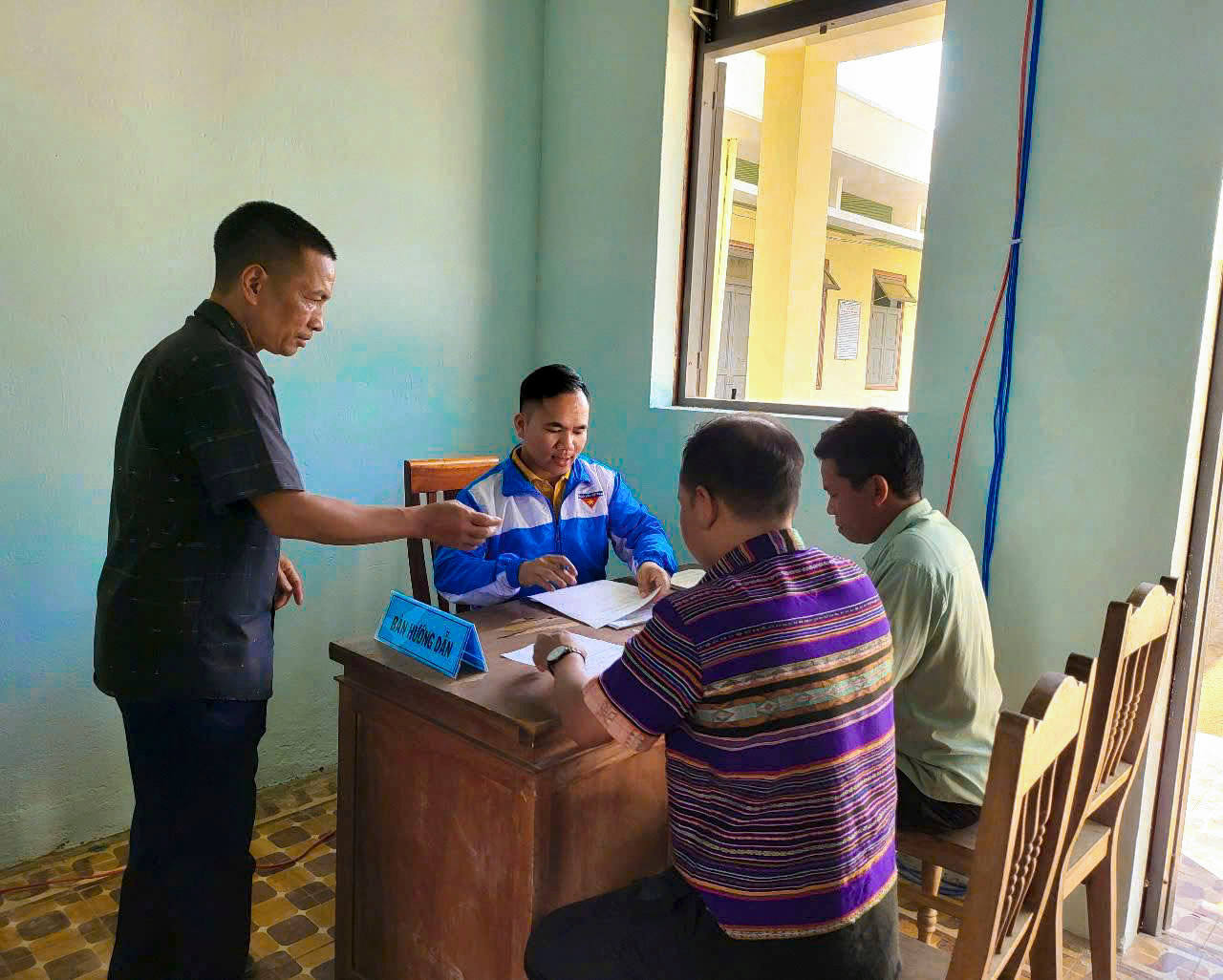 Đồng bào Cơ Tu mang theo giấy tờ, hồ sơ đến thực hiện các thủ tục hành chính như đăng ký khai sinh, xác nhận cư trú, kê khai thông tin định danh điện tử trên Cổng dịch vụ công được bạn trẻ hướng dẫn cụ thể từng bước.