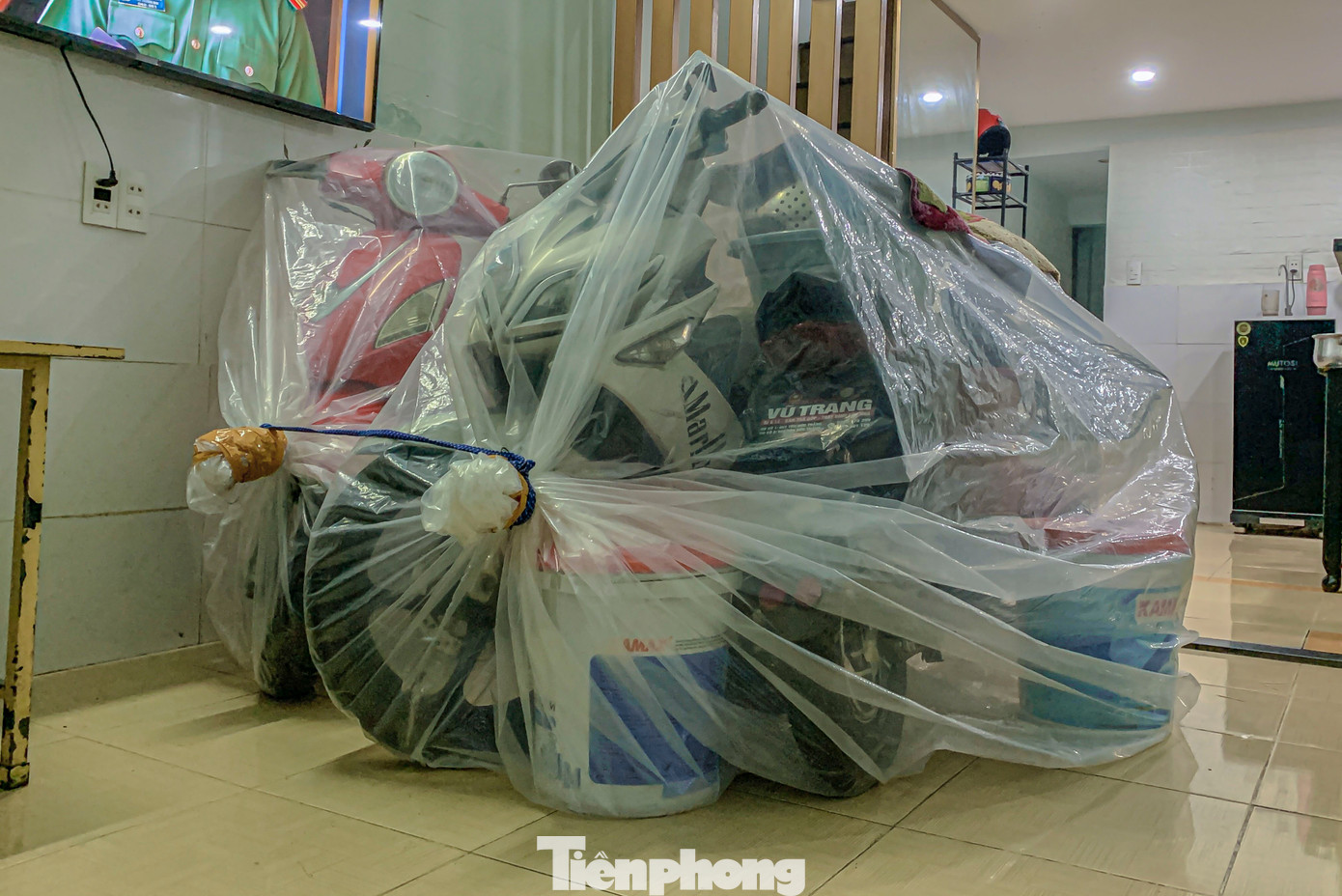 Người dân kê cao đồ đạc, dùng túi nilon bọc xe để chống nước tránh ảnh hư hại tài sản.