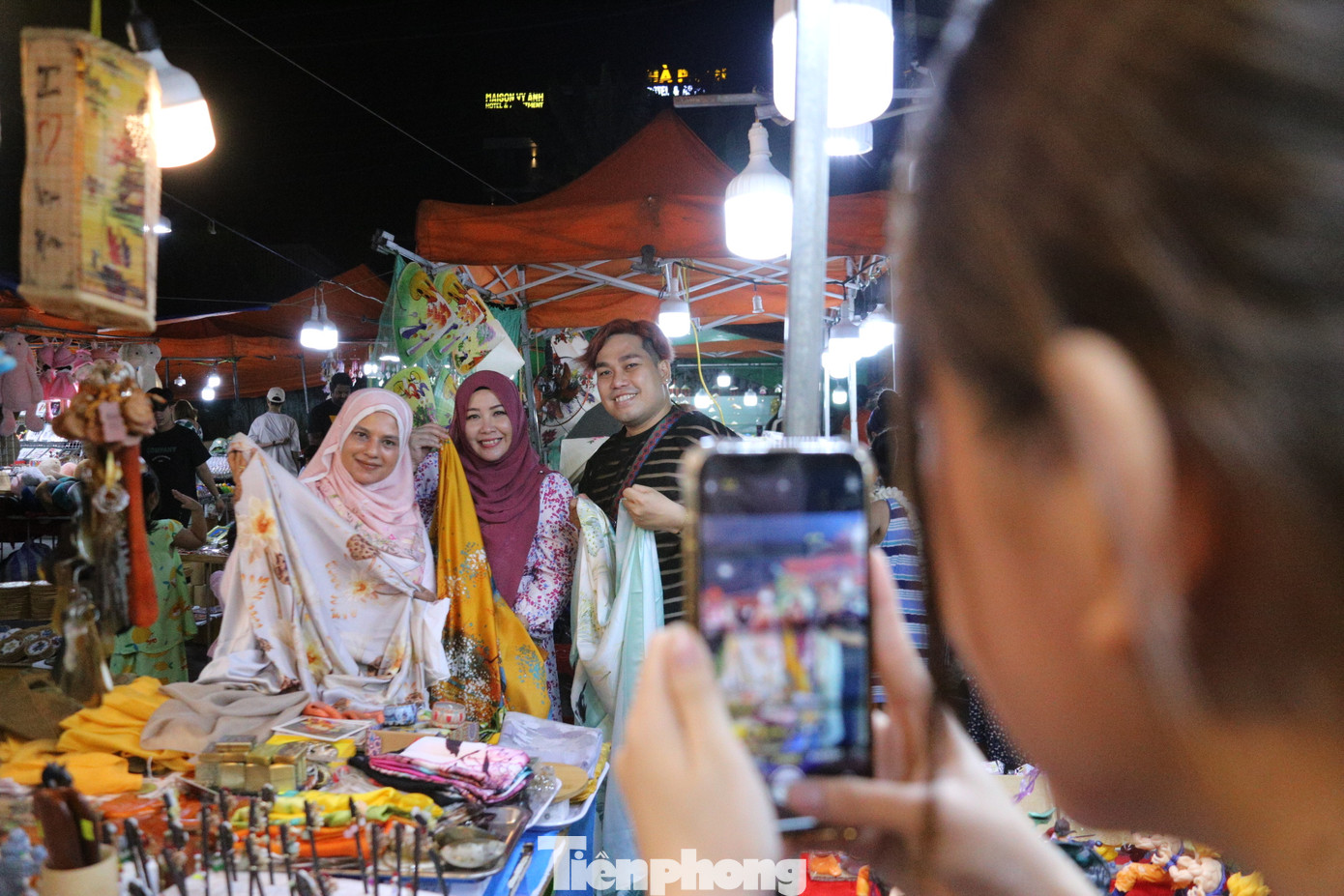 Du khách thích thú chụp hình bên các quầy bán hàng tại chợ đêm.