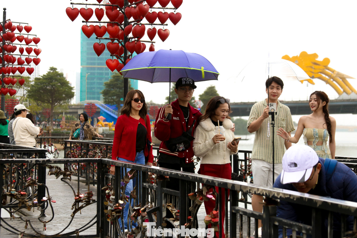 Dù thời tiết mưa phùn, giới trẻ vẫn đổ về cầu tình yêu, mang theo những chiếc khóa tình yêu sắc màu để cài lên thành cầu.