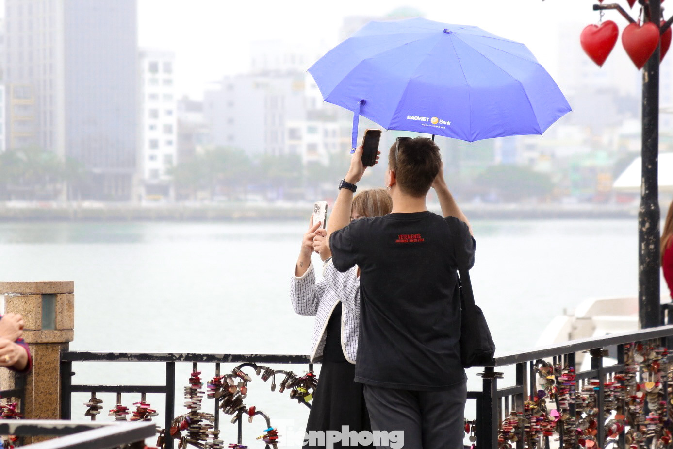 Dù thời tiết mưa phùn, giới trẻ vẫn đổ về cầu tình yêu, mang theo những chiếc khóa tình yêu sắc màu để cài lên thành cầu.