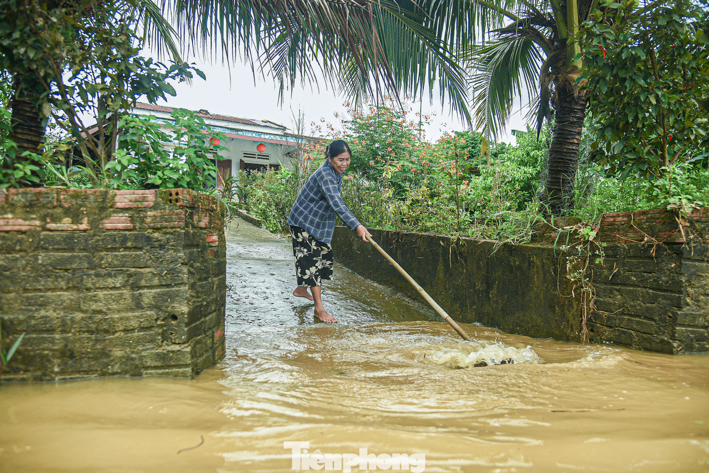 "Nước ngập từ chiều tối hôm qua đến sáng nay vẫn còn sâu nên chúng tôi không thể ra khỏi nhà. Đến trưa thì nước rút bớt nên tôi tranh thủ dọn bùn", bà Phạm Thị Tuyết chia sẻ.