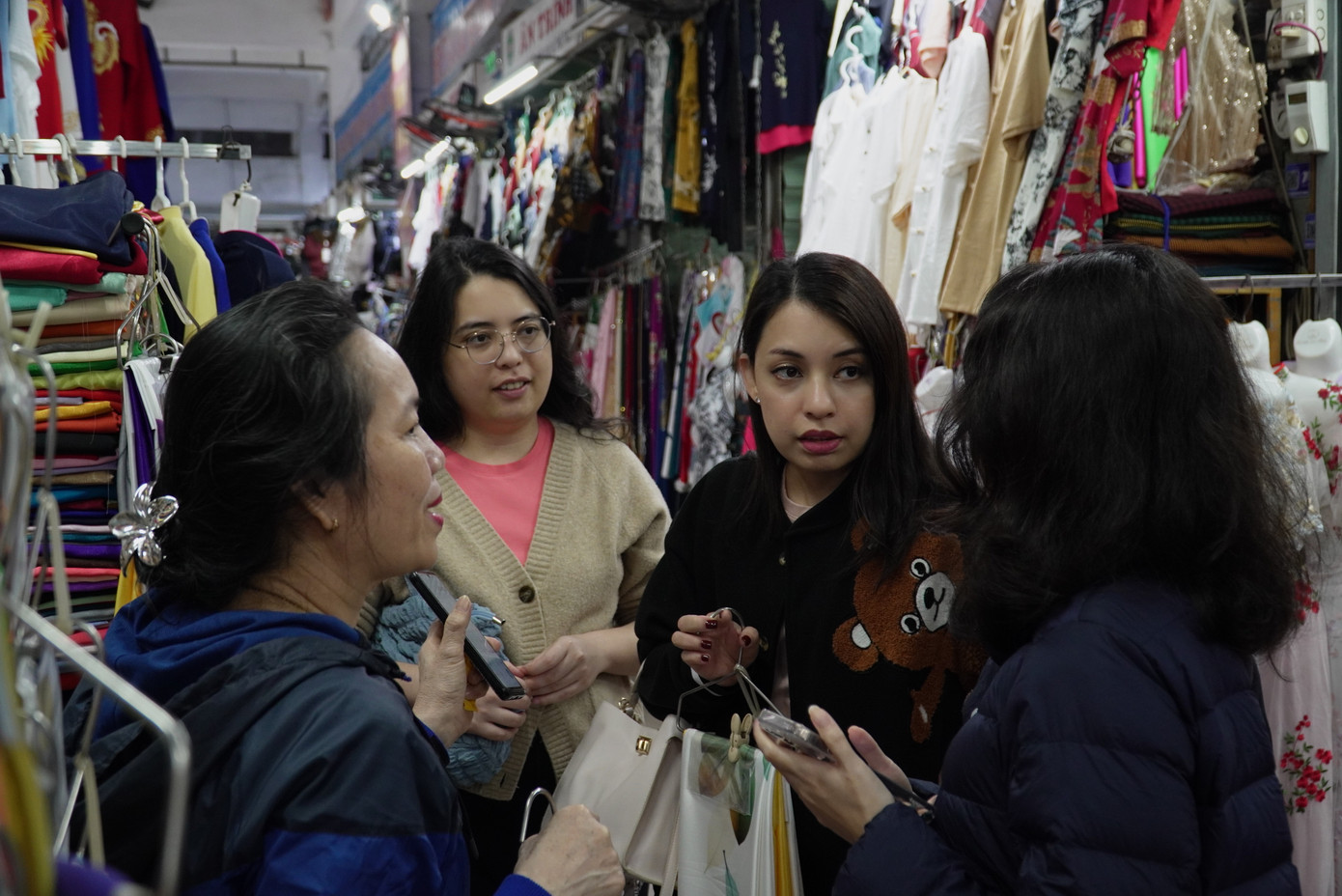 Nữ du khách tìm mua vải áo dài. Tại chợ Hàn còn có dịch vụ may đo áo dài thần tốc. Du khách được các thợ may may ngay tại chợ, sau một vài tiếng đồng hồ sẽ hoàn thành. Ảnh: Thanh Hiền.