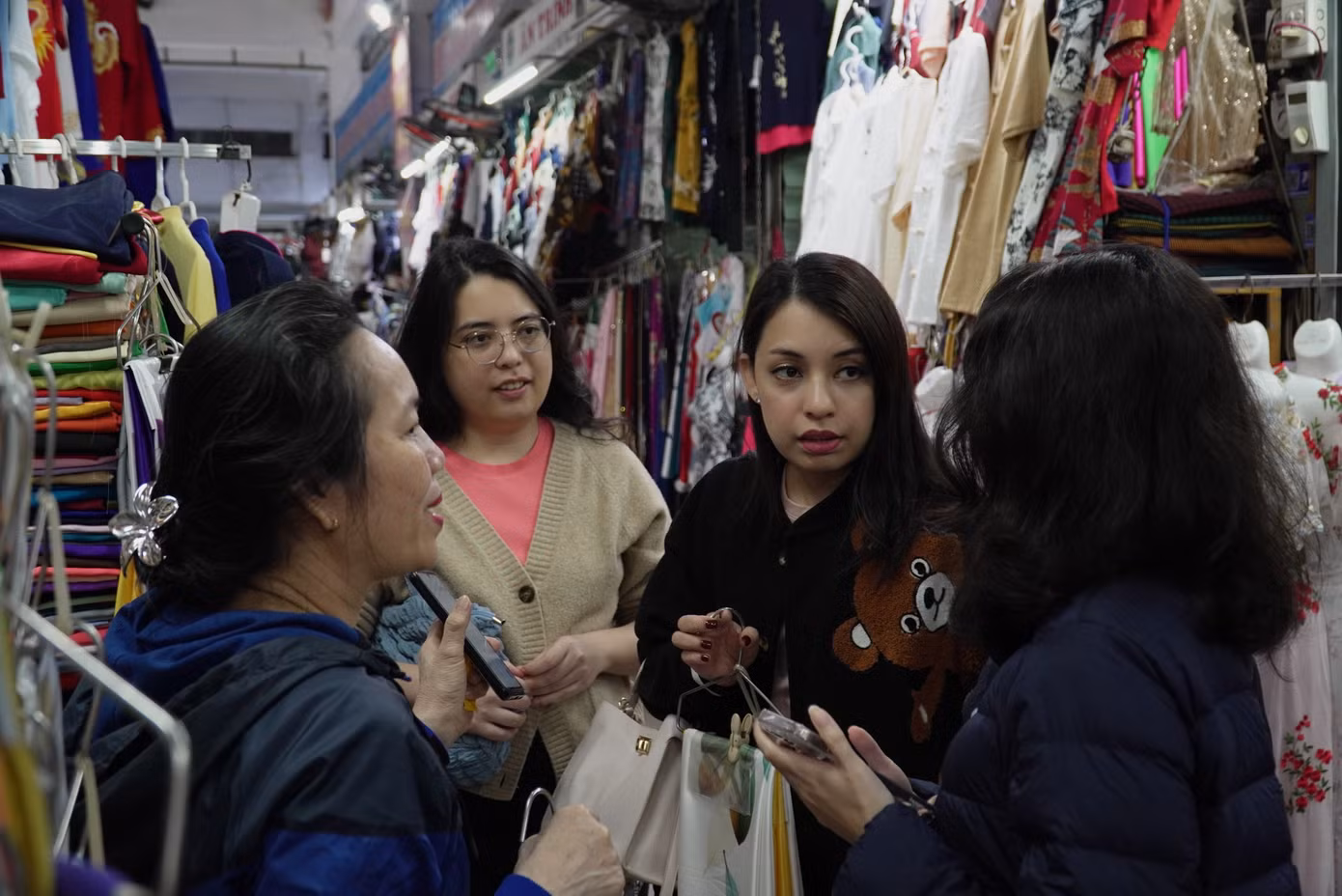 Nữ du khách tìm mua vải áo dài. Tại chợ Hàn còn có dịch vụ may đo áo dài thần tốc. Du khách được các thợ may may ngay tại chợ, sau một vài tiếng đồng hồ sẽ hoàn thành. Ảnh: Thanh Hiền.