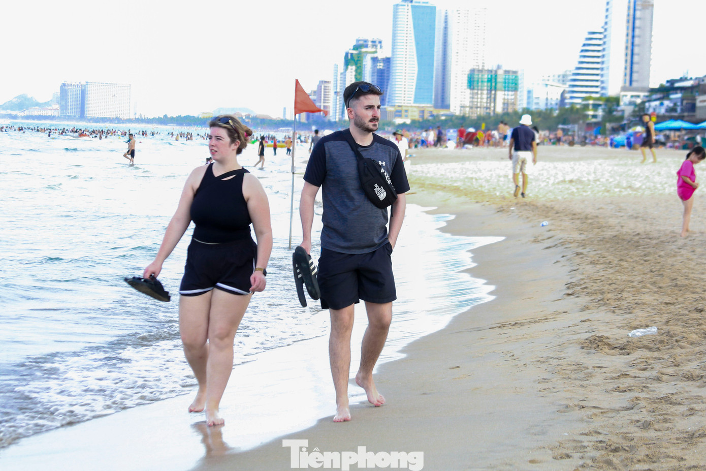 Nhiều du khách nước ngoài thích thú dạo trên bãi biển trong ngày hè oi bức, tận hưởng không khí trong lành.