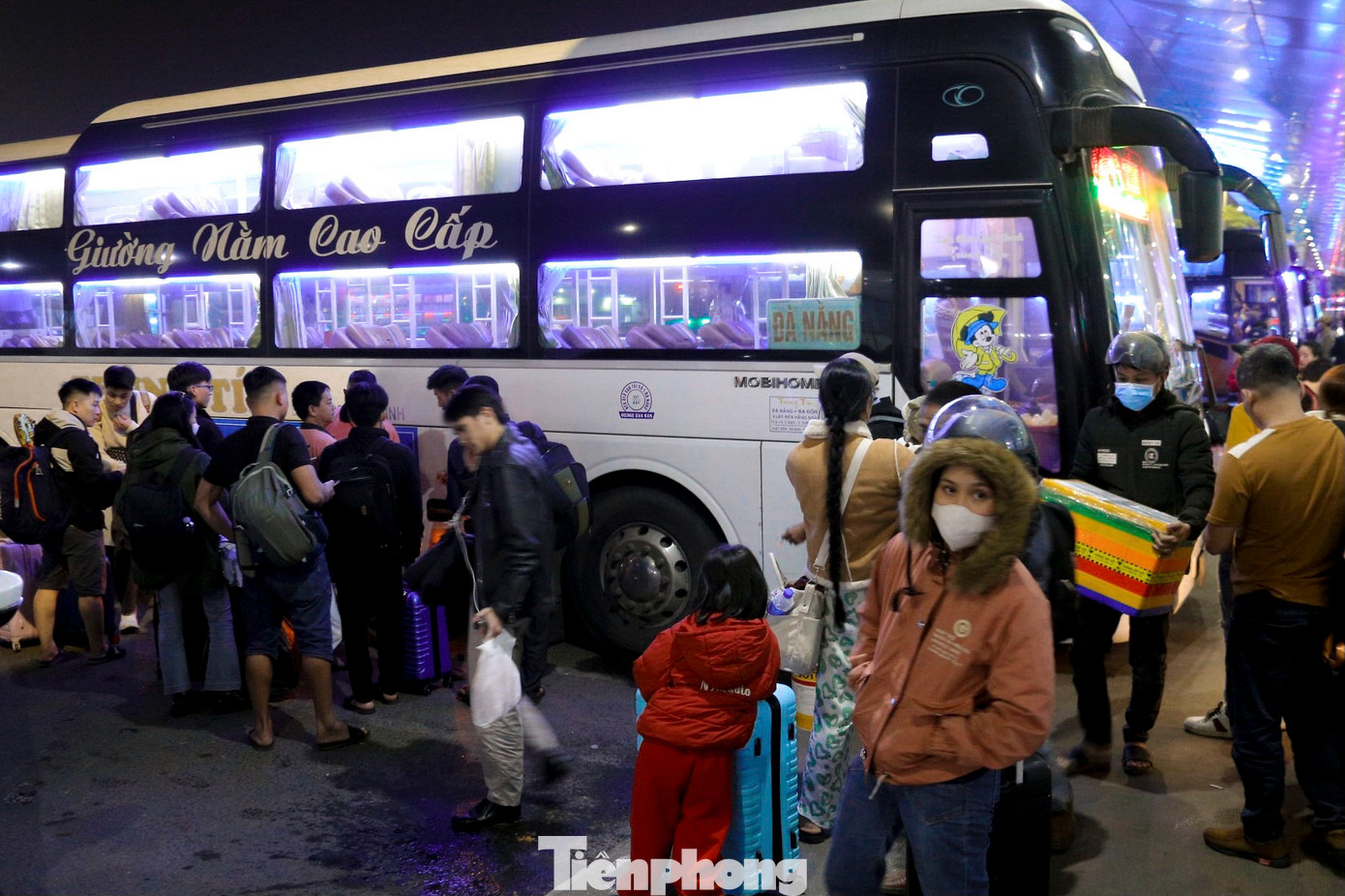 Hàng trăm người mang theo hành lý cồng kềnh để lên xe về quê, nhiều nhân viên nhà xe tất bật xếp hành lý của khách lên xe.