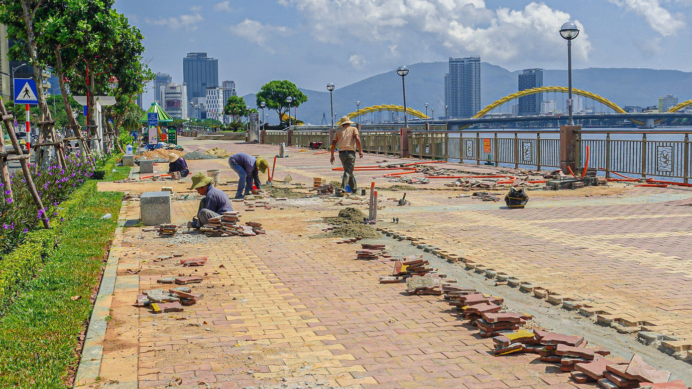 Công nhân đang tiến hành lát gạch, thi công những hạng mục tại vỉa hè phố đi bộ Bạch Đằng.