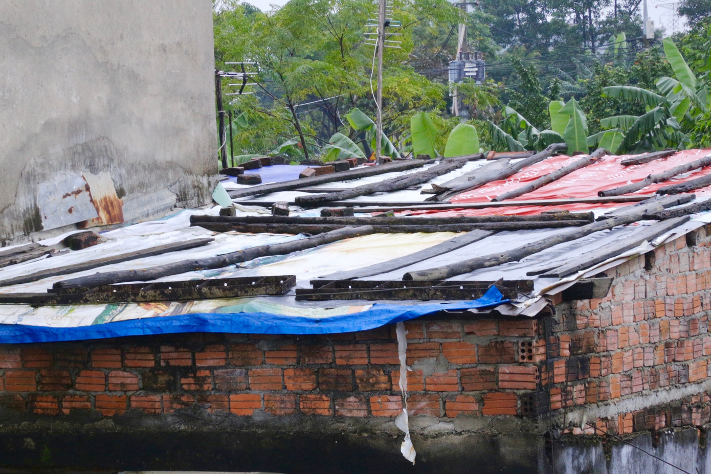 Những ngôi nhà xập xệ, xuống cấp được người dân che chắn tạm bợ sống qua mùa mưa.