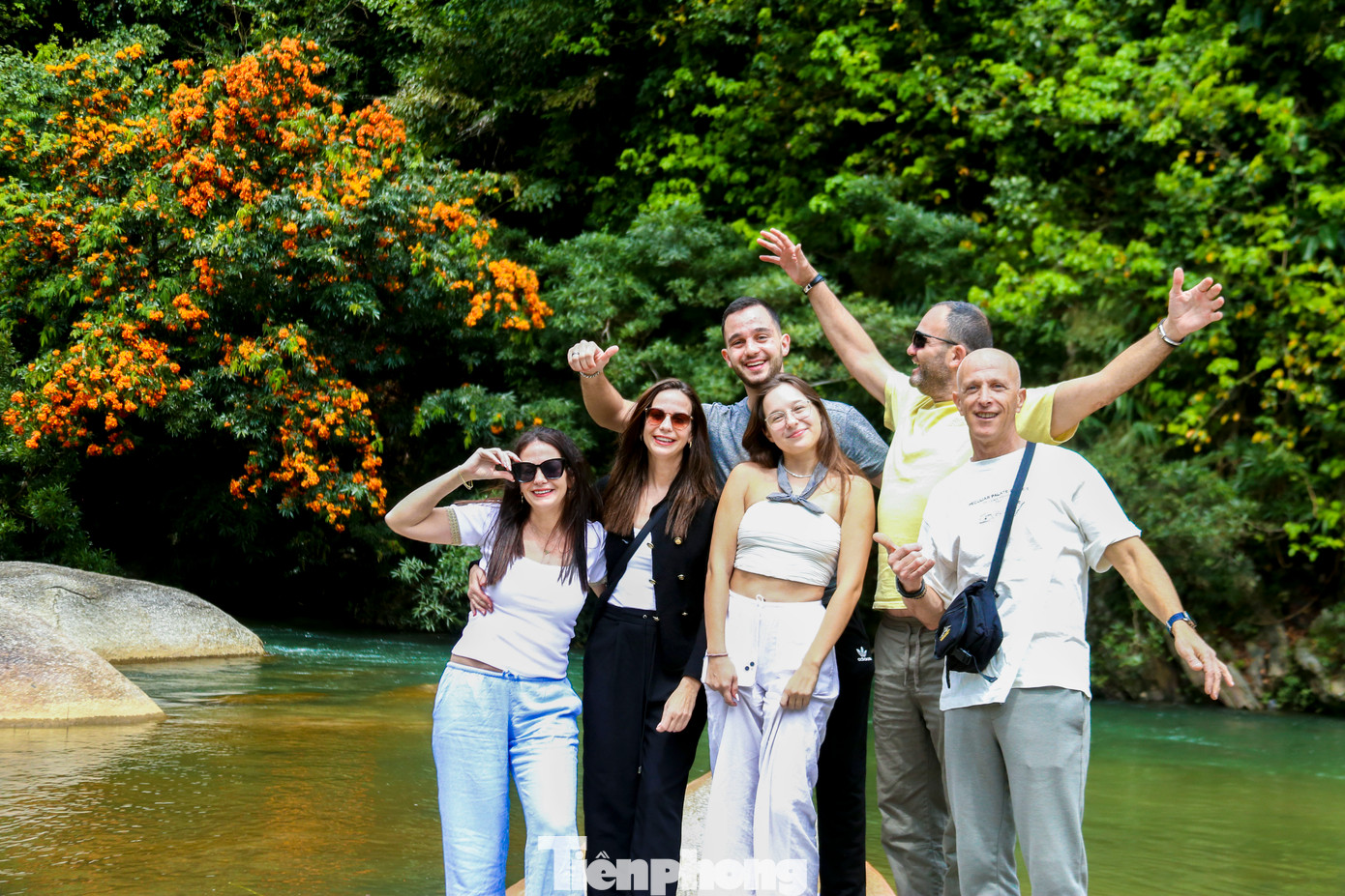 Du khách thích thú tạo dáng, chụp hình dưới những cây hoa rì rừng đầy màu sắc.