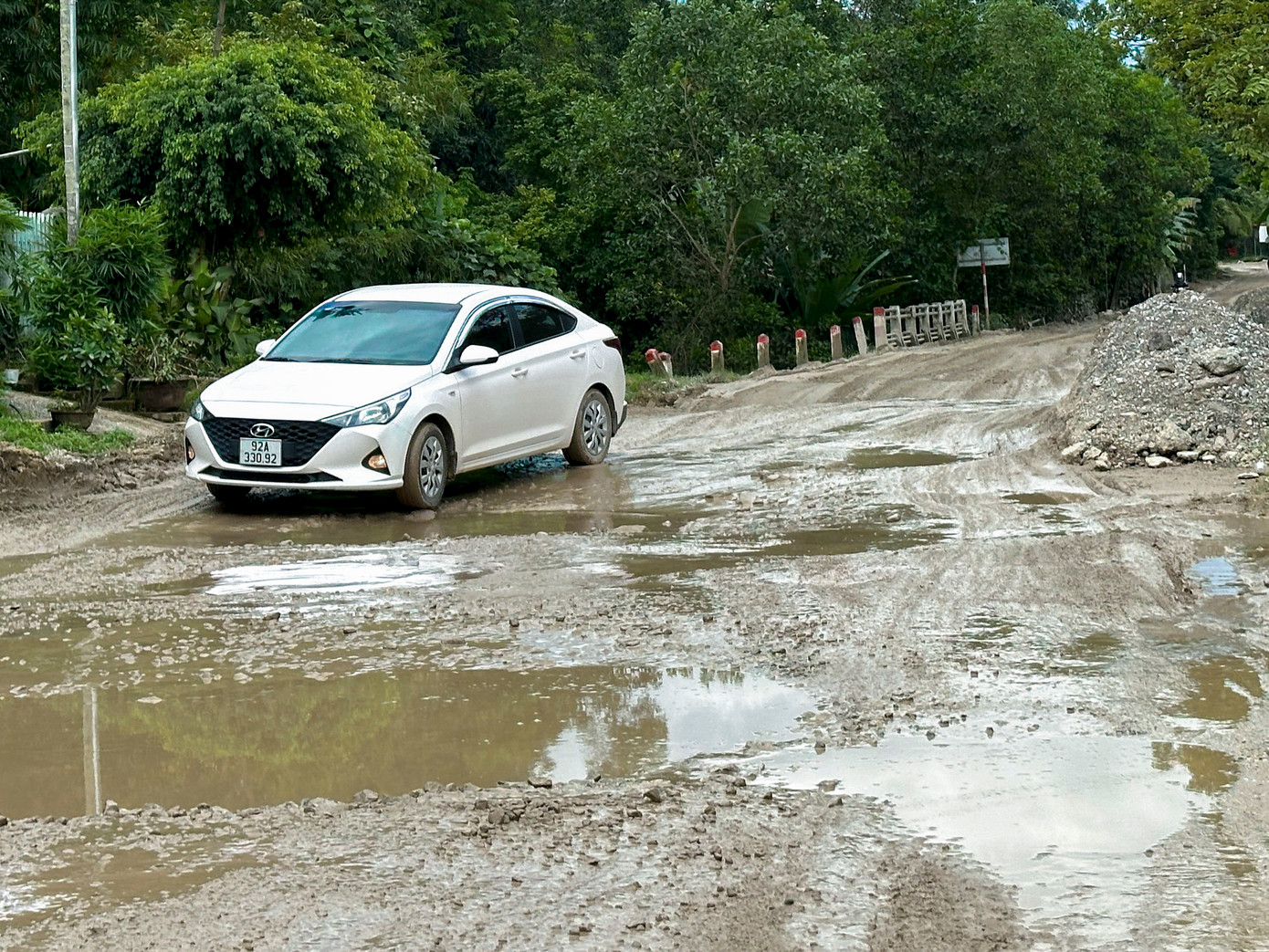 Lớp nhựa mặt đường bong tróc, đường lồi lõm như ruộng cày. Mưa xuống lầy lội, nắng thì bụi mù mịt. Nhiều nhà dân ven đường sống khổ với ô nhiễm.