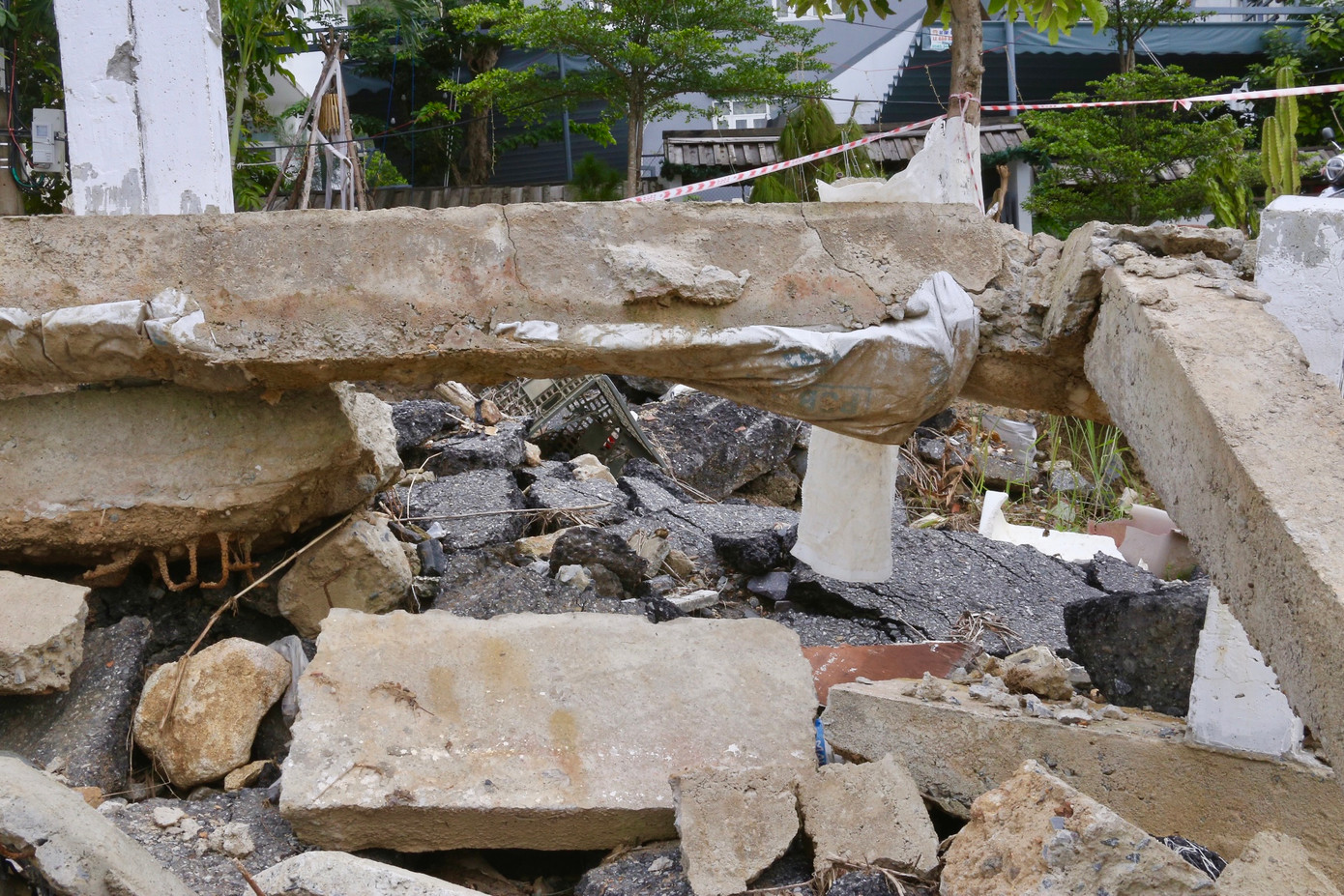 Ghi nhận của Tiền Phong, điểm sạt lở dài hàng chục mét, đất đá ngổn ngang. Vị trí sạt lở ngày càng ăn sâu vào tuyến đường, nhiều mảng bê tông nằm nham nhở.