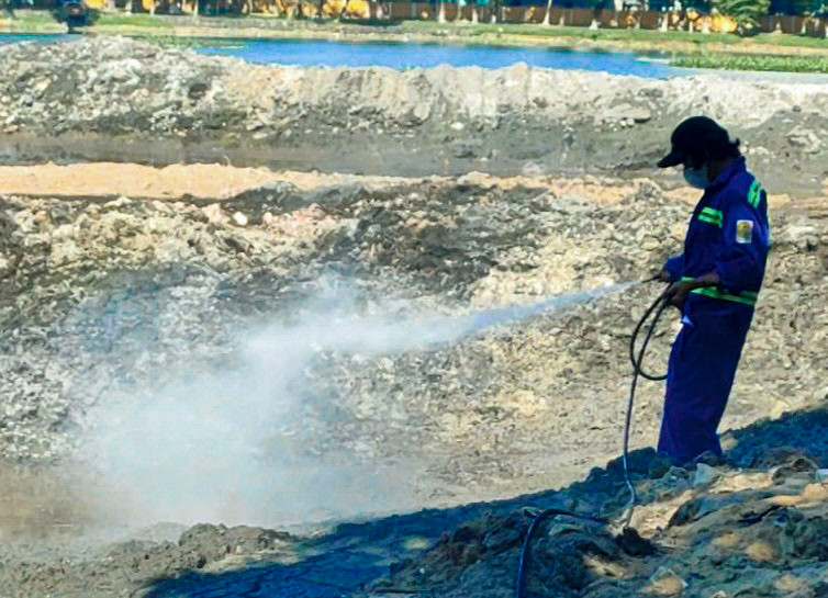 Công nhân phun dung dịch hóa chất khử mùi hôi tại hồ.