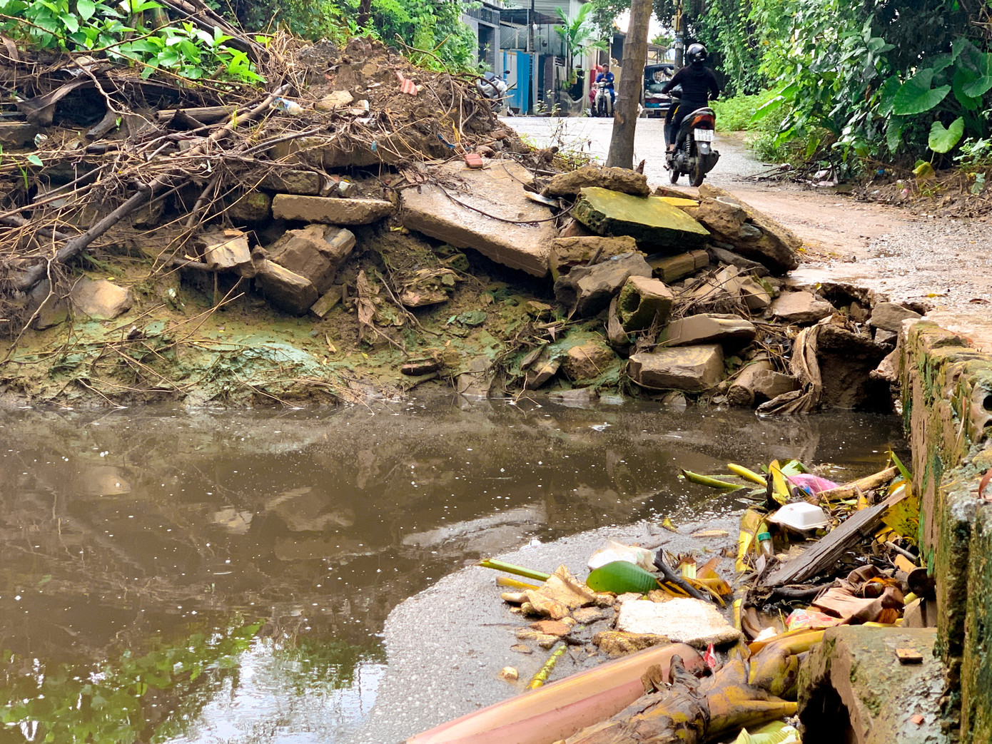 Nước thải đen ngòm, rác thải ứ đọng tại miệng cống không thoát ra được. Nước thải đen ngòm, rác thải ứ đọng tại miệng cống không thoát ra được.
