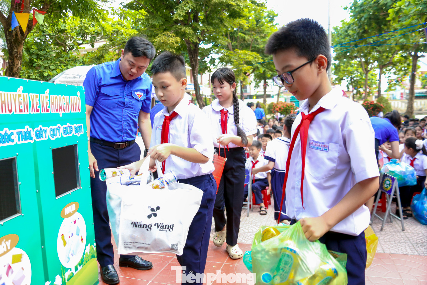 Các em học sinh, đội viên, thiếu niên nhi đồng đang sinh hoạt tại các khối lớp tiến hành bỏ rác thải tài nguyên thu gom được vào xe phân loại.