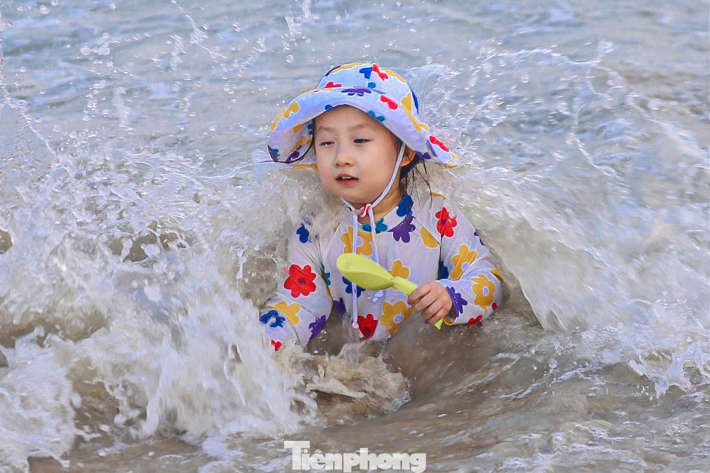 Nhiều trẻ em hào hứng khi được bố mẹ dắt ra biển vui chơi, tắm mát.