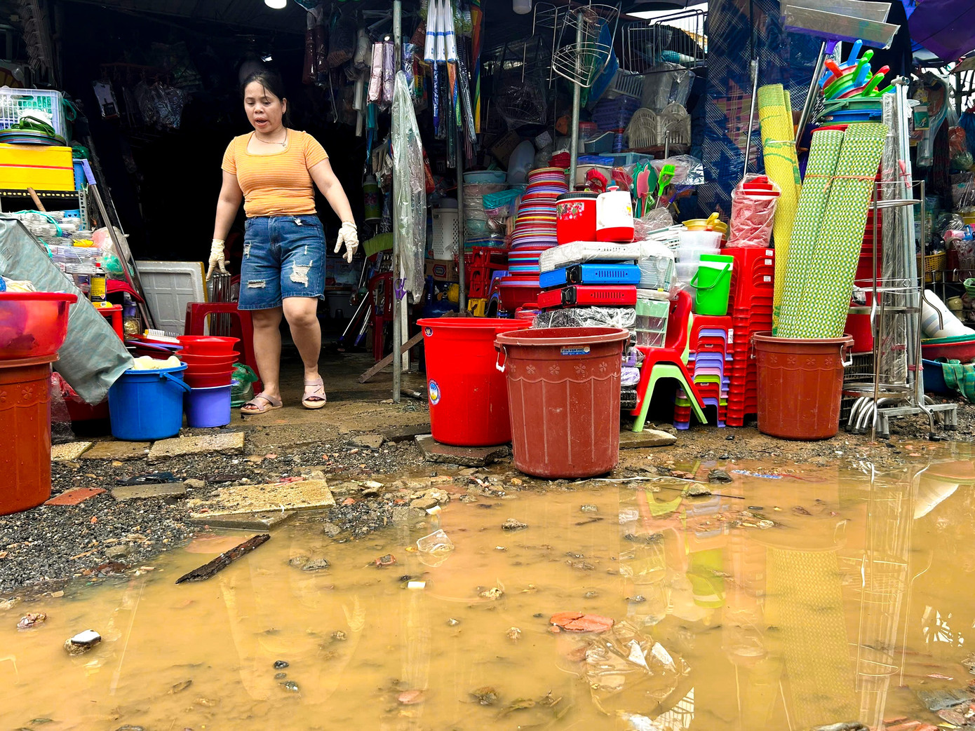 Chị Lê Thị Kiều Loan, tiểu thương bán đồ gia dụng cho biết, nước lũ dâng quá nhanh khiến các hộ buôn bán phải vật lộn giữa dòng nước để cứu hàng. “Giữa mùa hè hiếm khi mưa lớn như vậy. Nước lên bất ngờ, chúng tôi không kịp trở tay, nhiều mặt hàng bị cuốn trôi. Những thứ như chăn, chiếu, đồ điện tử giờ gần như mất trắng”, chị Loan chia sẻ.