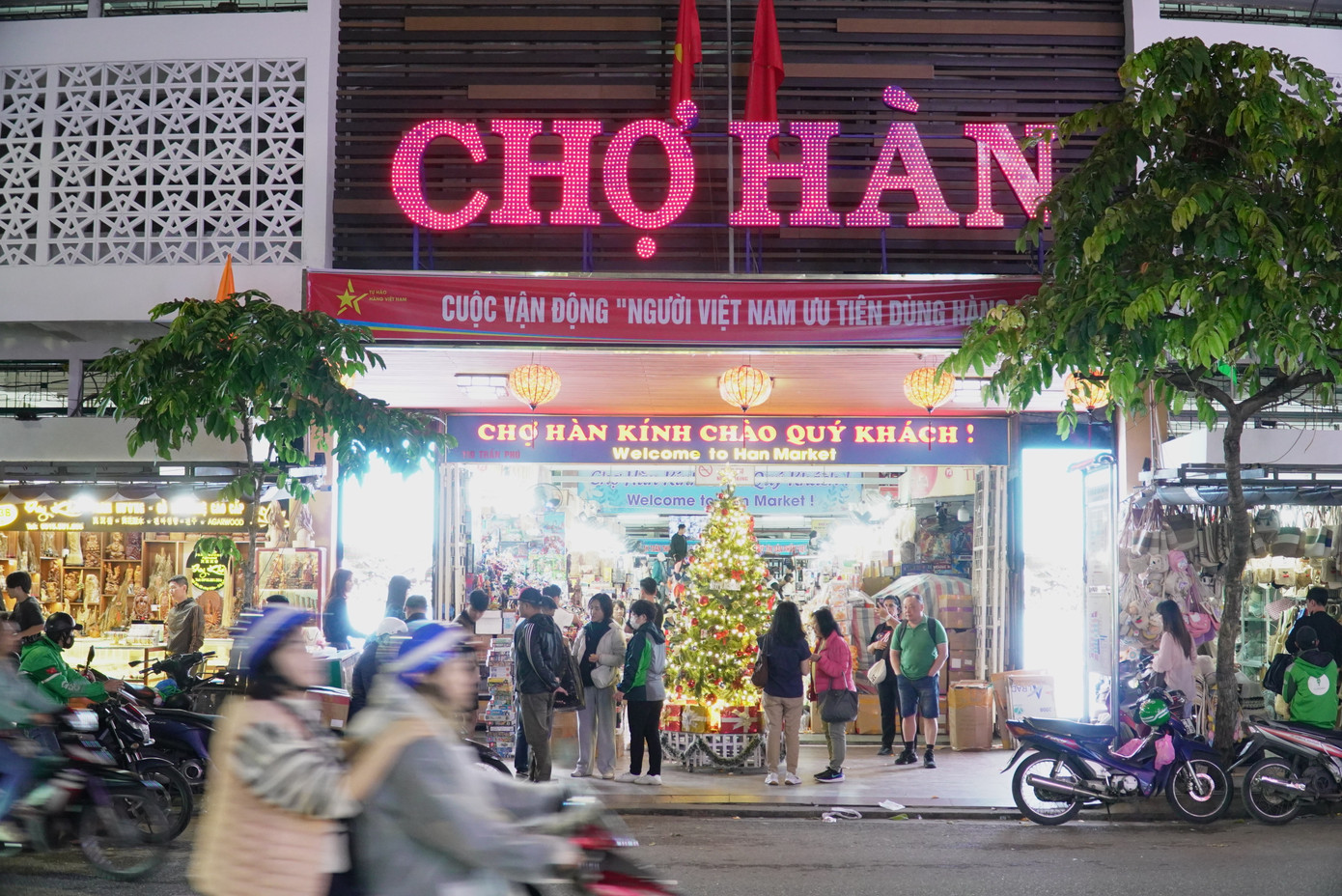 Chợ Hàn đã sáng đèn nhưng du khách vẫn kéo đến nườm nượp. Chị Nguyễn Thu Trang (31 tuổi, hướng dẫn viên du lịch) cho hay do thời tiết mưa lạnh nên lịch trình tham quan của khách đều được lùi muộn hơn một vài tiếng đồng hồ. Những điểm đến ngoài trời ưu tiên cho ban ngày. Còn chợ hoặc các khu vui chơi trong nhà thường sắp xếp vào chiều tối. "Nhiều khách còn lo đi muộn chợ sẽ đóng cửa. Đối với khách quốc tế, chợ Hàn là địa điểm không thể bỏ qua khi đến Đà Nẵng", chị Trang nói. Ảnh: Thanh Hiền.