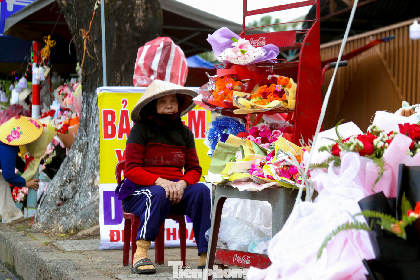 Nhiều người ngồi đợi khách đến mua hoa, quà ngày lễ Valentine.