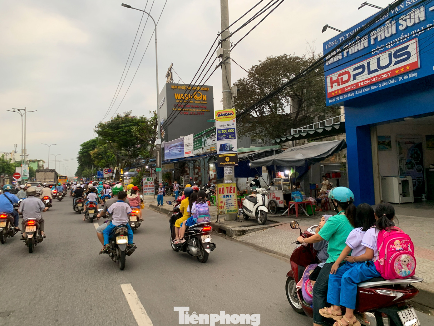 Rất nhiều phụ huynh đến đón nhưng không đội mũ bảo hiểm cho con, thậm chí “kẹp ba” di chuyển trên đường tiềm ẩn rất nhiều nguy hiểm.