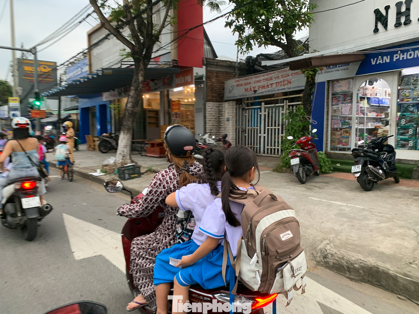 Rất nhiều phụ huynh đến đón nhưng không đội mũ bảo hiểm cho con, thậm chí “kẹp ba” di chuyển trên đường tiềm ẩn rất nhiều nguy hiểm.