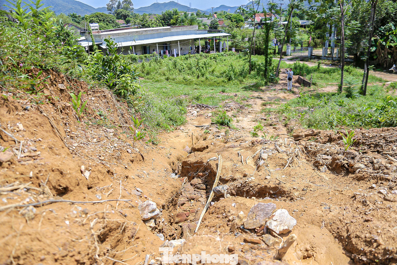 Phía sau nhà ông Phú là cả ngọn đồi đang bị sạt lở, chỉ cần vài trận mưa lớn thì đất đá từ đồi núi có thể đổ xuống.