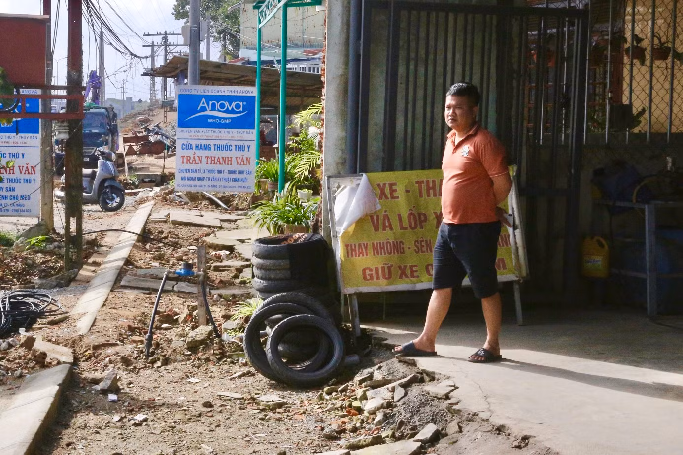 Theo người dân sống cạnh dự án, trời nắng bụi bặm, mưa thì bùn lầy khiến việc đi lại rất khó khăn. Gần cả năm nay, họ phải lót ván để đi lại vì nền nhà cao hơn mặt đường.
