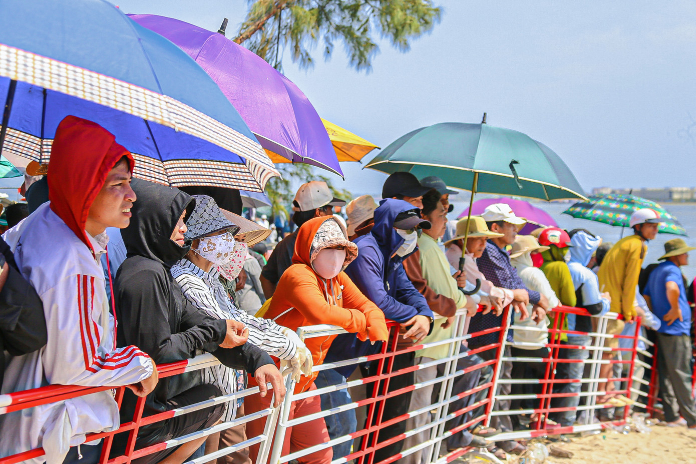 Dù thời tiết nắng nóng nhưng nhiều người vẫn đội nắng, che ô để cổ vũ.