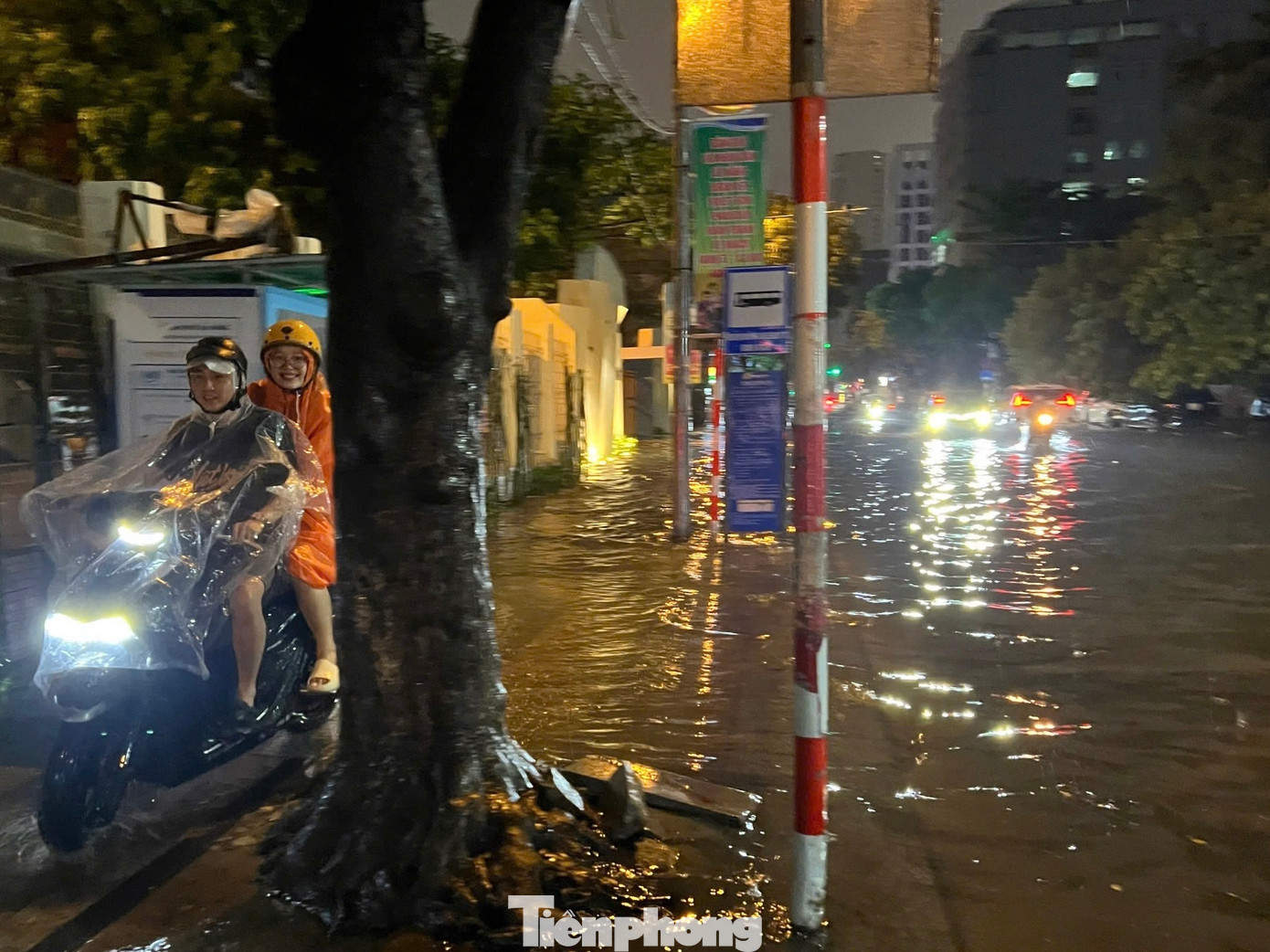 Nhiều xe máy phải leo lên vỉa hè để di chuyển qua đoạn ngập tránh chết máy.