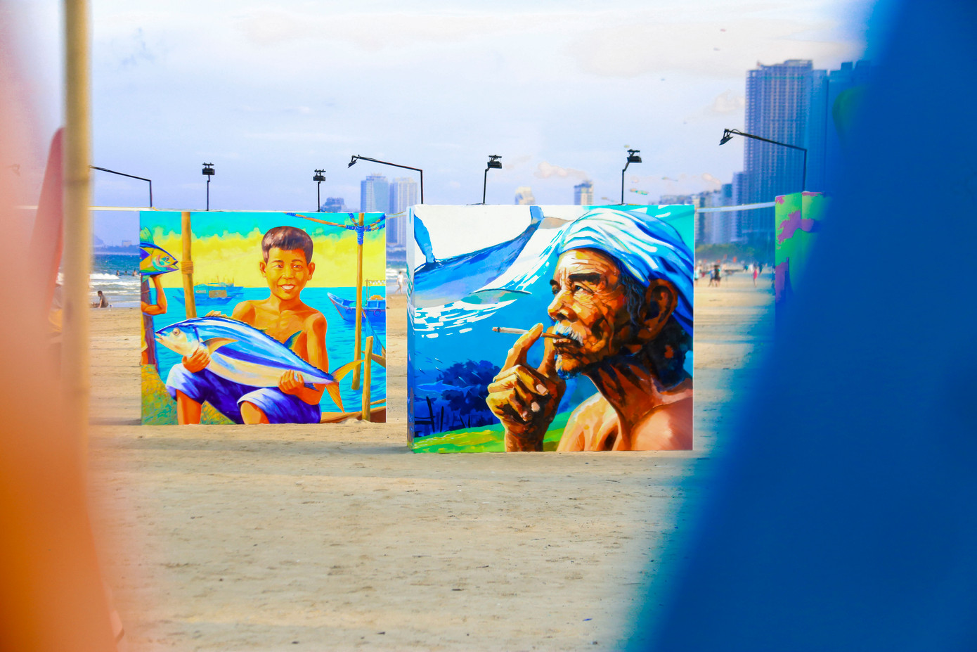 Đặc biệt, “Vườn bích họa” mang đến cảm xúc sâu lắng qua loạt tranh vẽ chân thực trên nền gỗ sơn chống nước cao 2,1m. Các bức họa mô tả cảnh phơi cá, người quăng lưới, đan lưới hay ánh mắt trẻ thơ bên mẹt cá khô… Những khoảnh khắc đời thường ấy góp phần tái hiện vẻ đẹp lao động, sự cần mẫn và tình người đậm chất biển khơi.