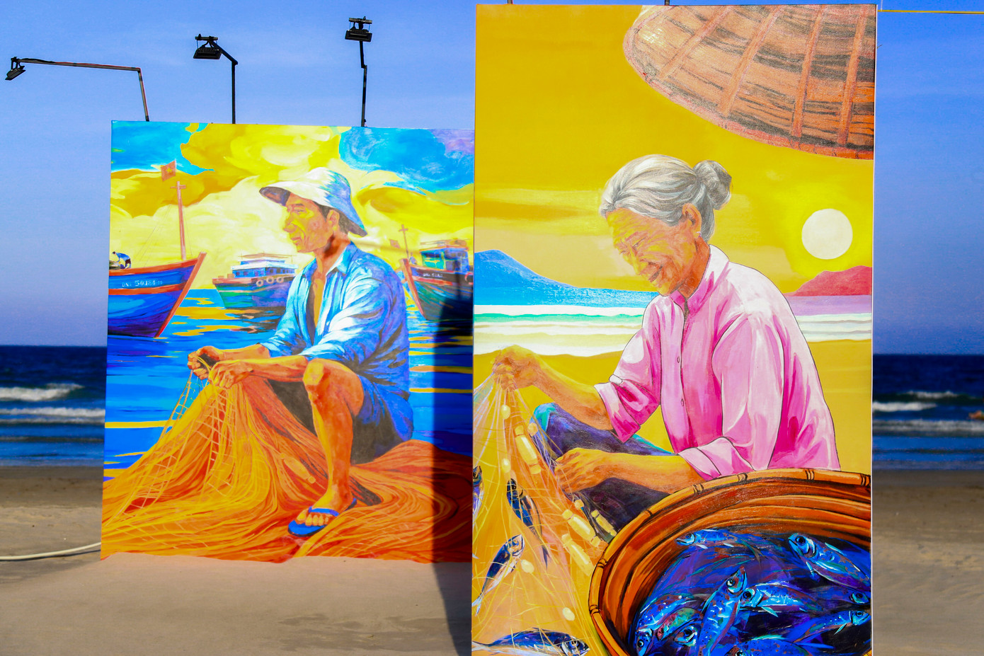 Đặc biệt, “Vườn bích họa” mang đến cảm xúc sâu lắng qua loạt tranh vẽ chân thực trên nền gỗ sơn chống nước cao 2,1m. Các bức họa mô tả cảnh phơi cá, người quăng lưới, đan lưới hay ánh mắt trẻ thơ bên mẹt cá khô… Những khoảnh khắc đời thường ấy góp phần tái hiện vẻ đẹp lao động, sự cần mẫn và tình người đậm chất biển khơi.