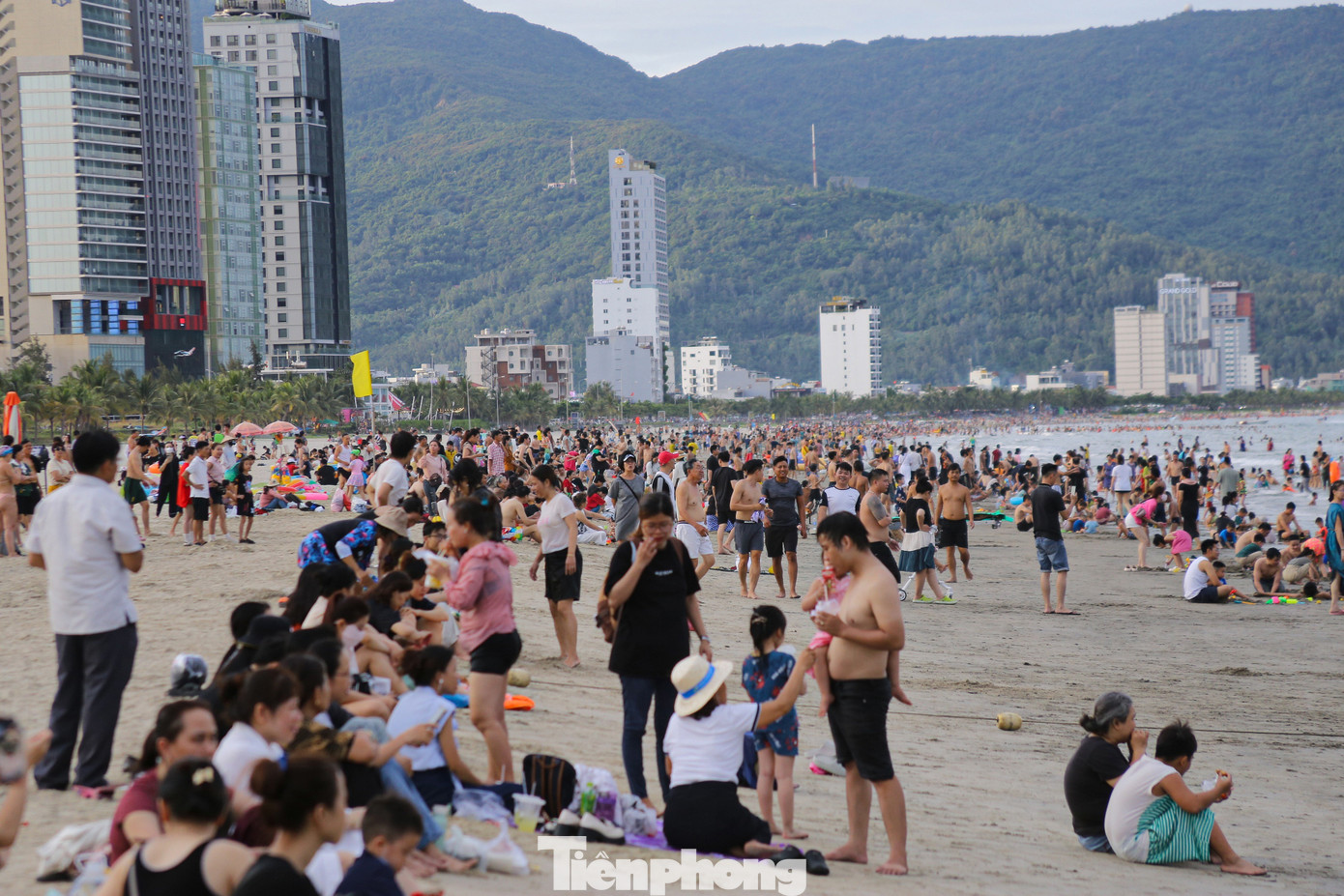 Từ 15h30, dọc bãi biển Mỹ Khê dòng người đông nghịt, chen chân ra biển tắm mát.