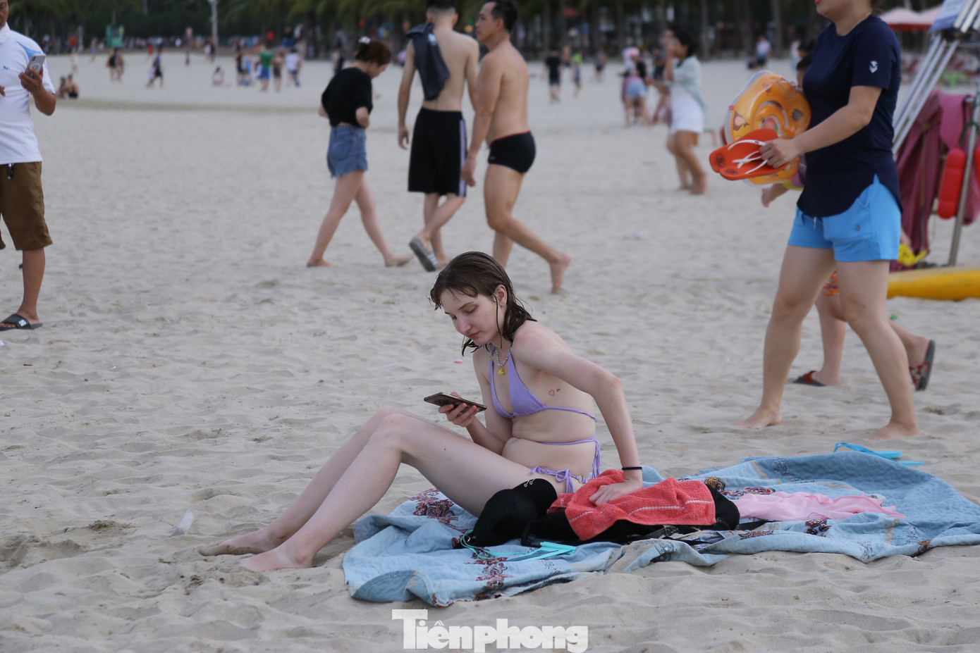 Nhiều du khách nước ngoài ngồi hóng gió trên bãi biển.