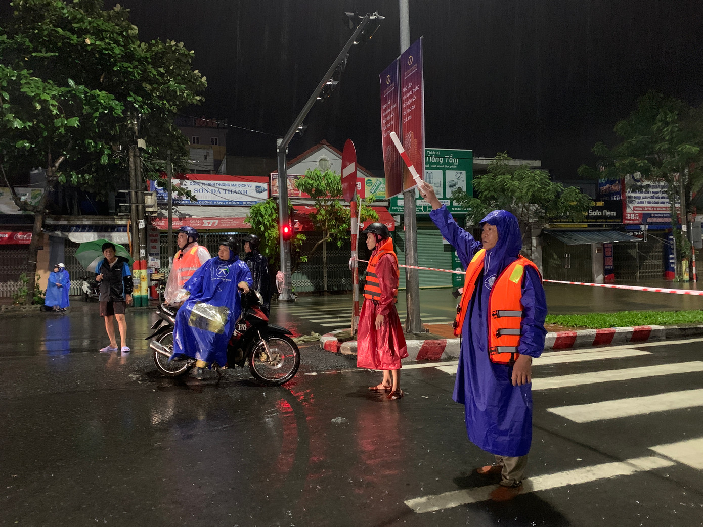 Trắng đêm đứng trong mưa lạnh, lực lượng chức năng phường Hòa Minh chốt chặn không cho người dân đi vào vùng nước sâu.