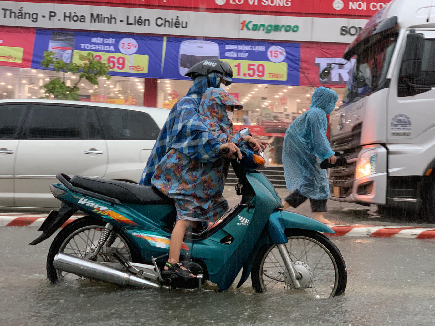 Một em nhỏ được mẹ cho ngồi trên xe dắt qua đoạn đường ngập. Một em nhỏ được mẹ cho ngồi trên xe dắt qua đoạn đường ngập.