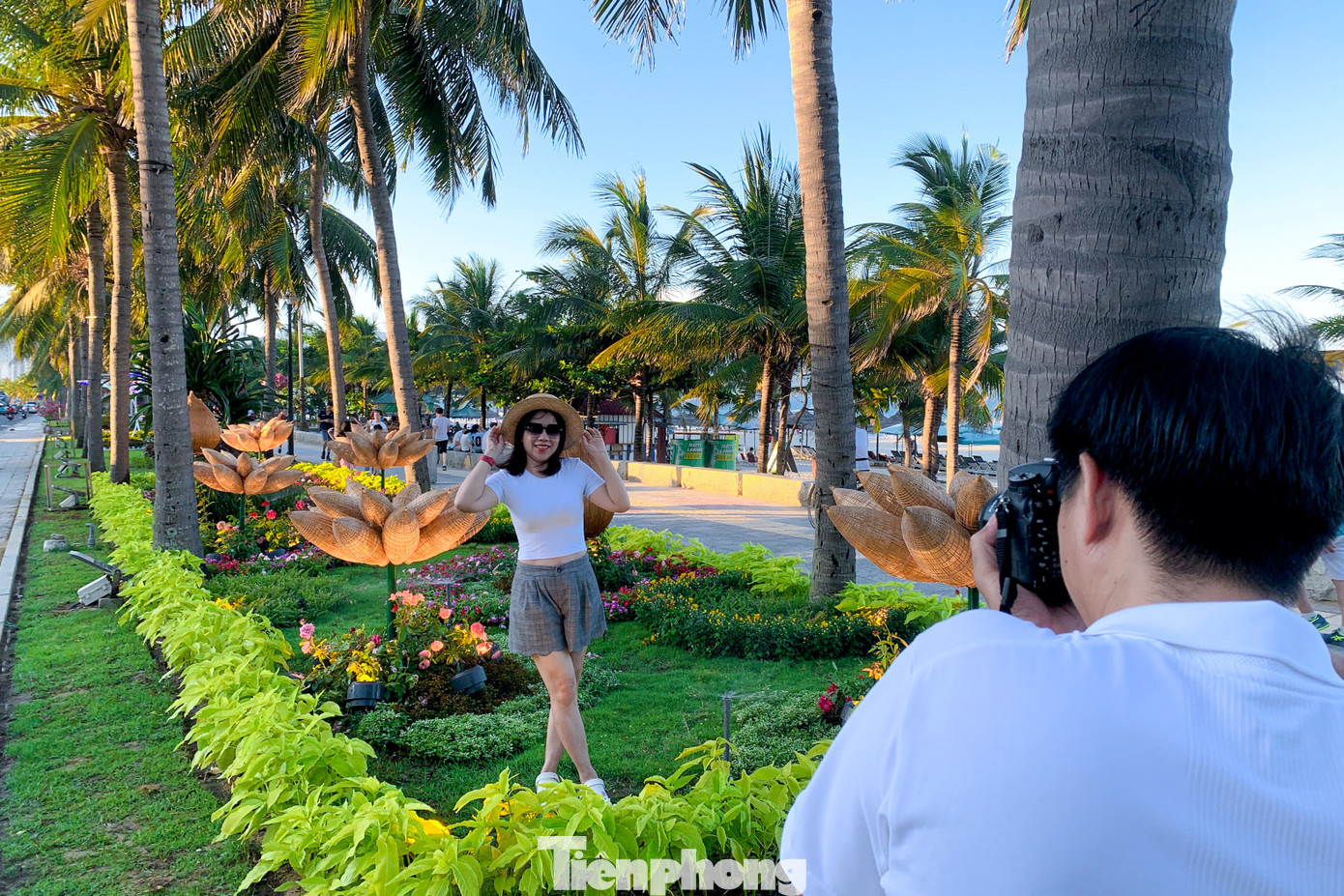 Nhiều du khách thích thú đi dạo trên đường hoa ven biển, cùng nhau tạo dáng, chụp hình.