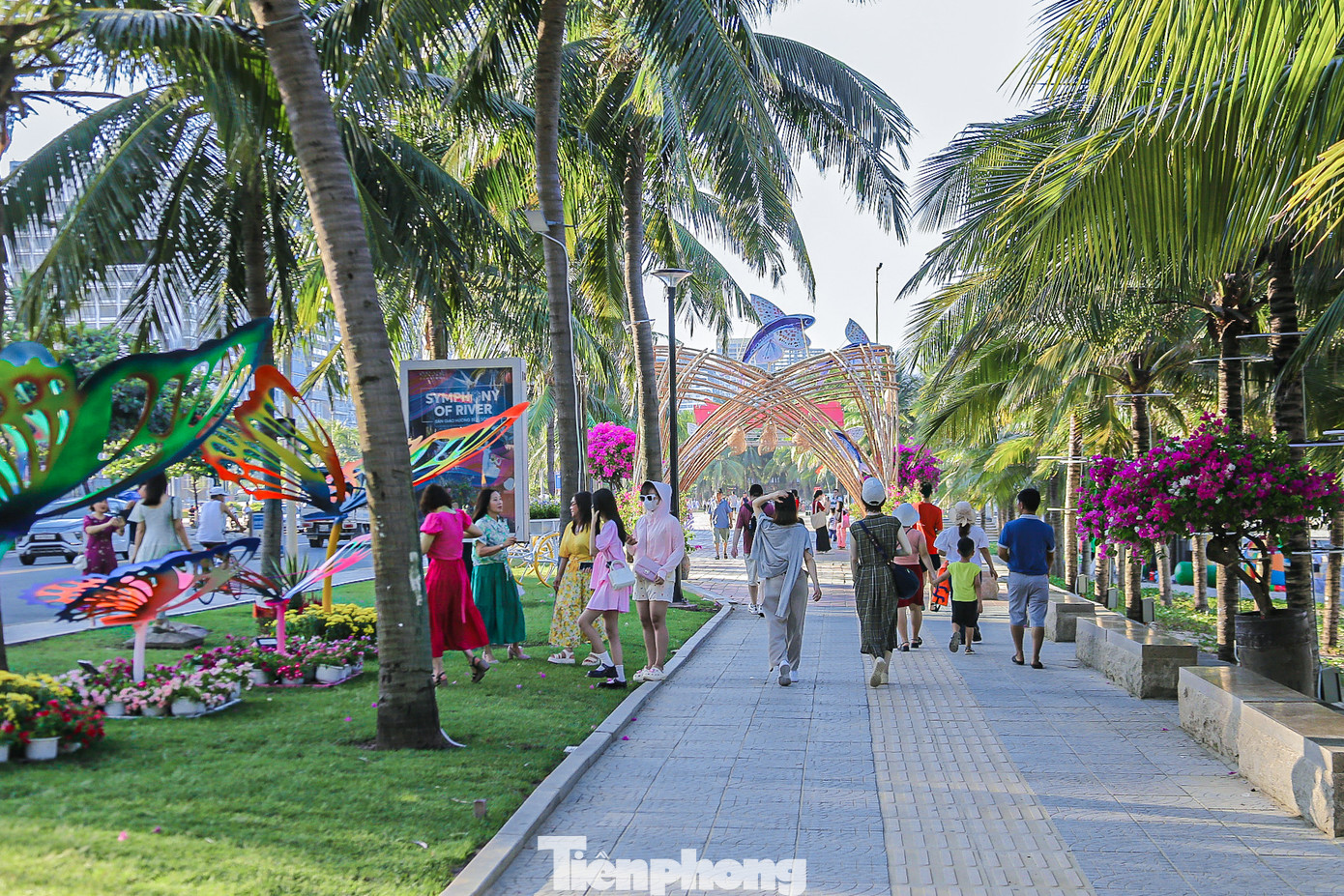 Nhiều du khách thích thú đi dạo trên đường hoa ven biển, cùng nhau tạo dáng, chụp hình.