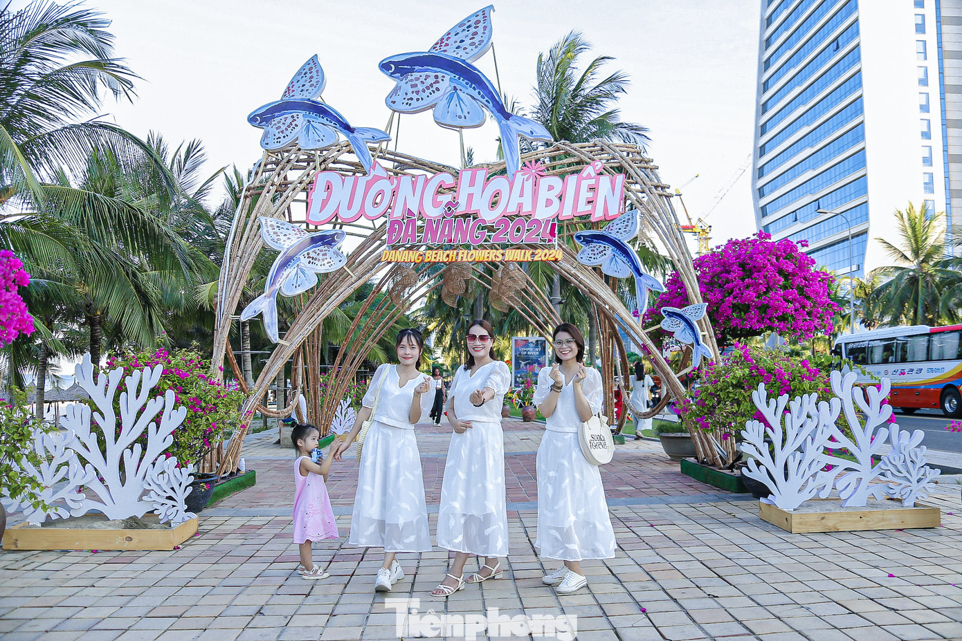 Nhiều du khách thích thú đi dạo trên đường hoa ven biển, cùng nhau tạo dáng, chụp hình.