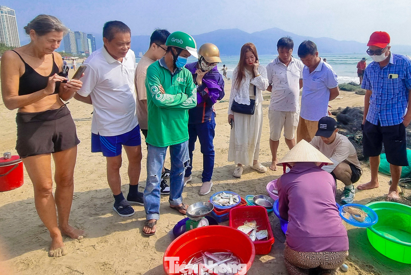 Nhiều du khách nước ngoài không giấu được sự thích thú khi lần đầu tiên trải nghiệm công việc kéo lưới của ngư dân vùng biển Đà Nẵng. Họ cùng nhau chụp ảnh để lưu giữ lại kỷ niệm khi đến Việt Nam.