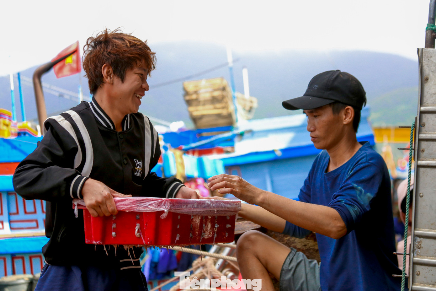 Sau 8 giờ sáng, những tàu đánh mực lần lượt vào bờ, chở theo những khay mực đầy ắp về cảng. Ngư dân tất bật chuyển những khay mực từ dưới khoang để vận chuyển vào chợ cá.