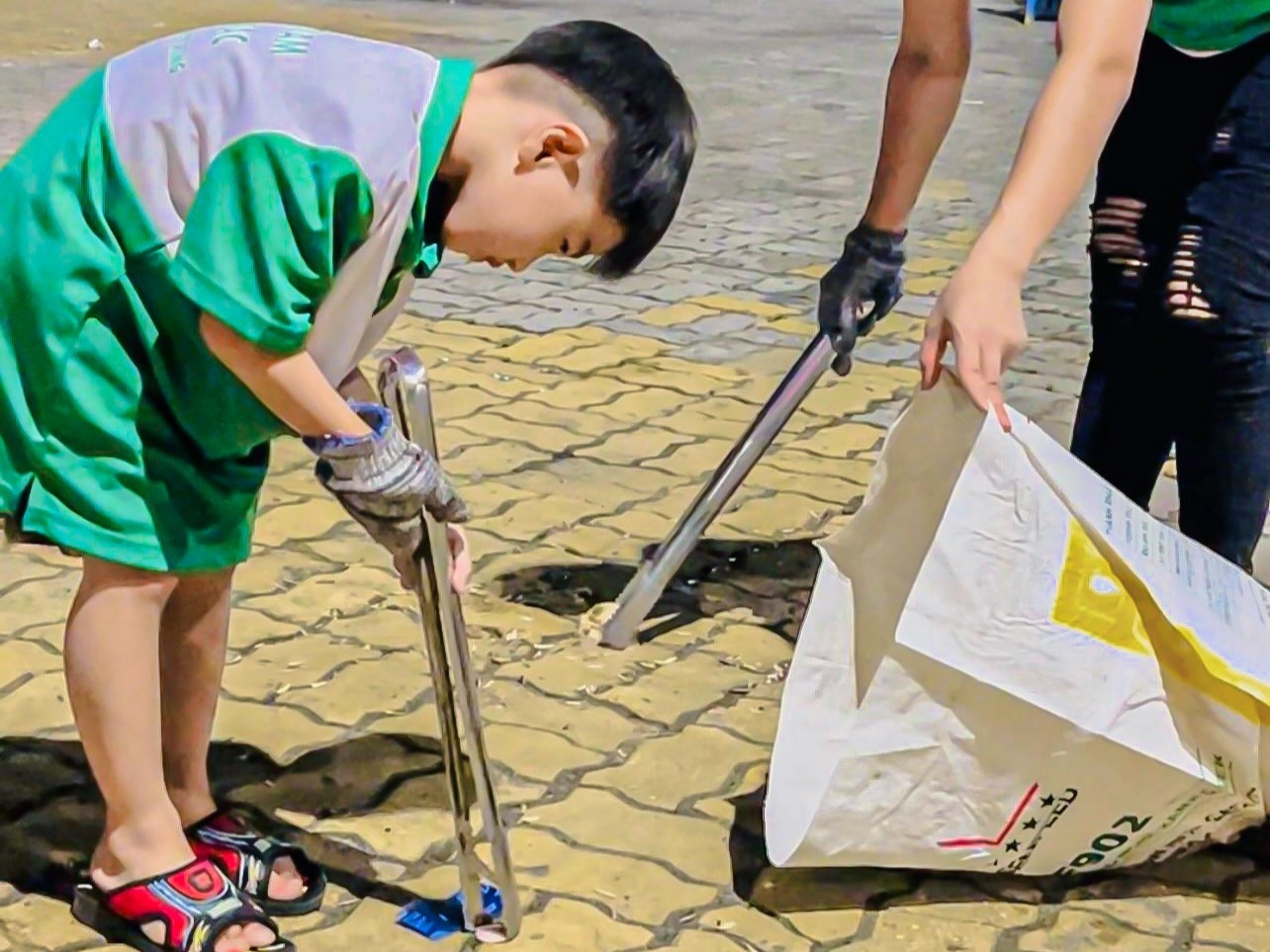 Nhiều em nhỏ cũng chung tay cùng các anh chị thu dọn rác sau khi kết thúc pháo hoa.