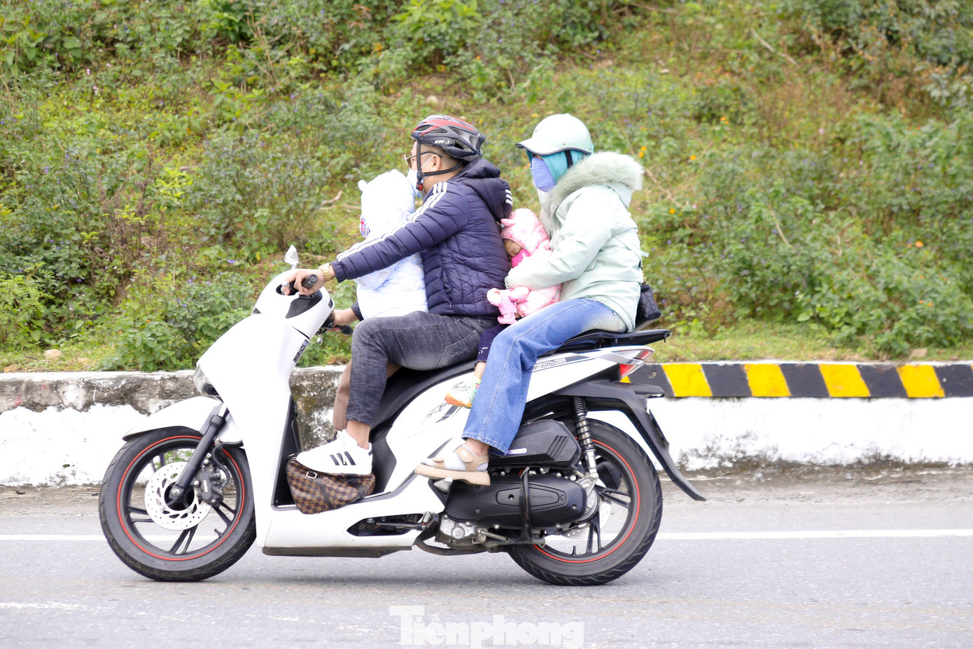 Các em nhỏ theo bố mẹ vượt đèo về quê ăn Tết.