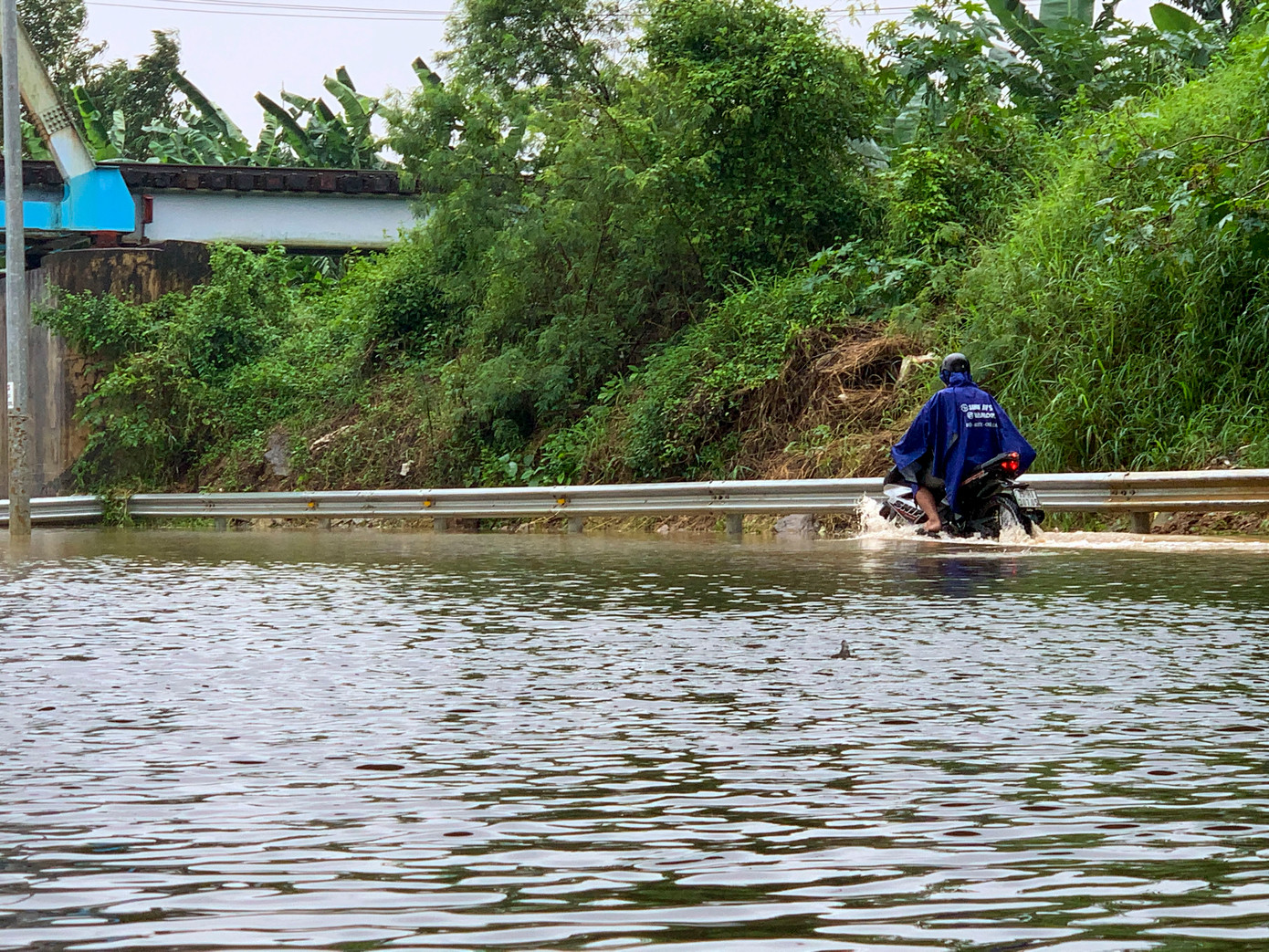 Nhiều người chạy lên lề đường, cố gắng vượt qua đoạn nước ngập.