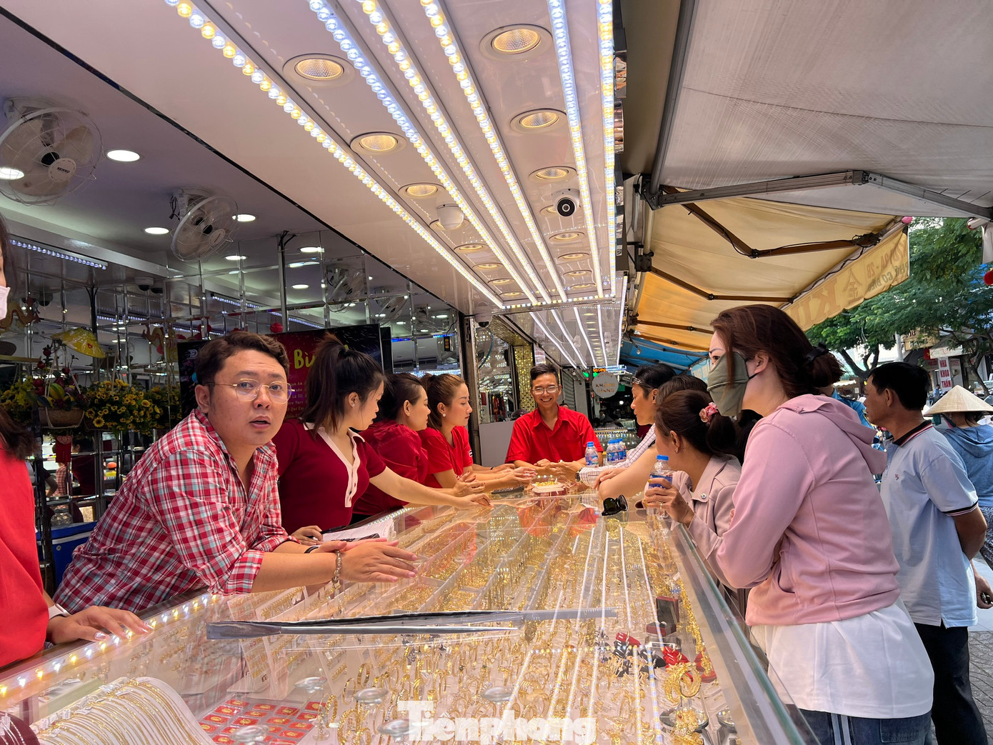 Khách mua vàng cầu may trước ngày vía Thần Tài. Tại TPHCM, hầu như không có cảnh xếp hàng chờ mua vàng, chỉ một vài cửa tiệm khá đông khách hơn ngày thường, trong đó khách thường mua nhẫn vàng hoặc vàng thẻ loại 1 chỉ và không mua nhiều.