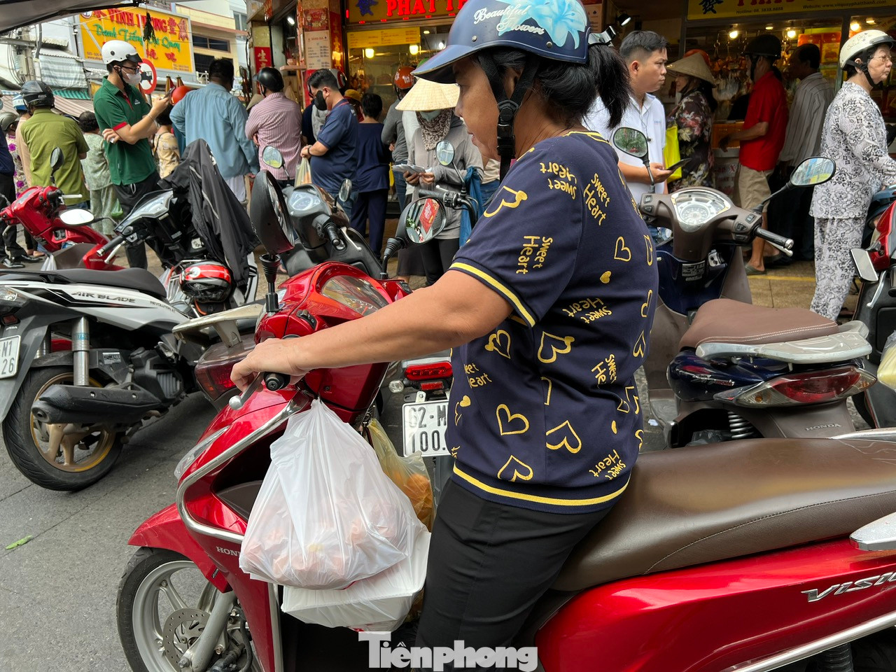 Một người thở phào nhẹ nhõm khi đã mua xong, lách qua khỏi dòng người đông đúc để về nhà bày mâm cúng Tết.