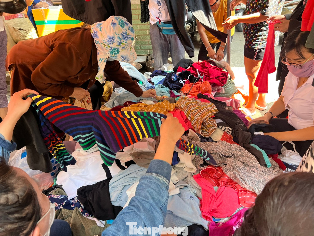 Quần áo được chất đống trên tấm bạt trải ngay mặt đường, khách có thể ngồi hàng giờ liền để xới tung đống đồ, chọn những chiếc áo quần thấy vừa mắt. Người bán cũng không nề hà chuyện phụ khách tìm hàng ưng ý và luôn tay đảo trộn quần áo từ dưới lên để khách dễ dàng tìm kiếm.